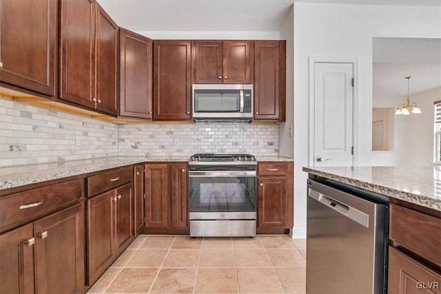 kitchen featuring a notable chandelier, stainless steel appliances, light stone countertops, and light tile patterned floors