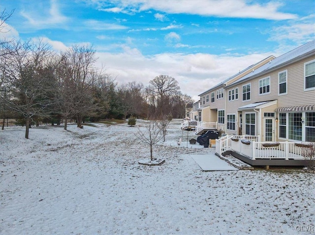 yard layered in snow with a wooden deck