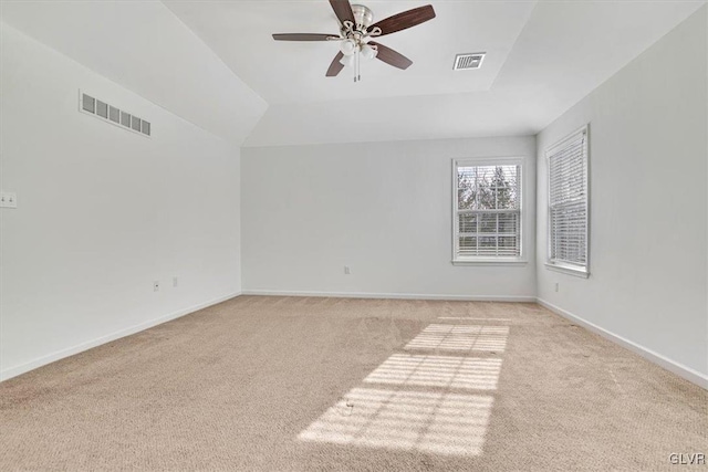 carpeted spare room featuring ceiling fan and vaulted ceiling