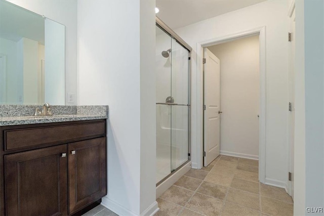 bathroom with a shower with door and vanity