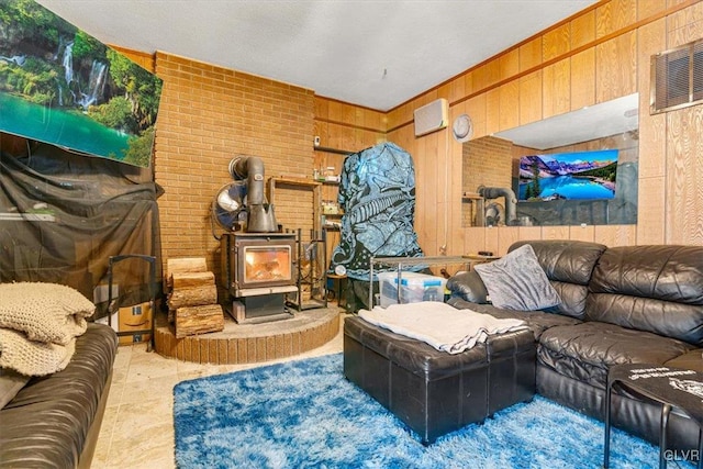 living room featuring brick wall, wood walls, and a wood stove