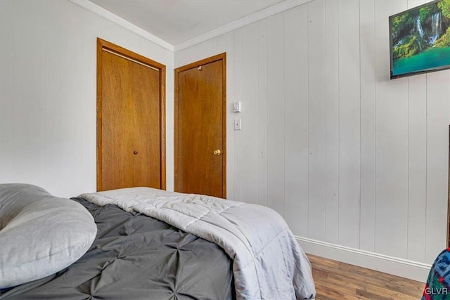 bedroom featuring ornamental molding and wood-type flooring