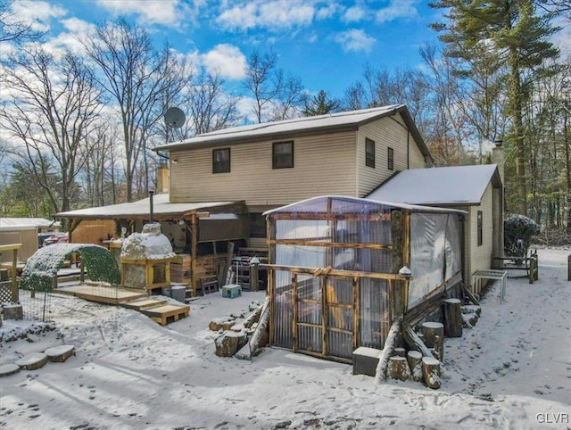 view of snow covered rear of property