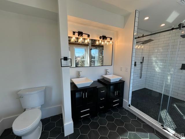 bathroom with toilet, a sink, and tile patterned floors