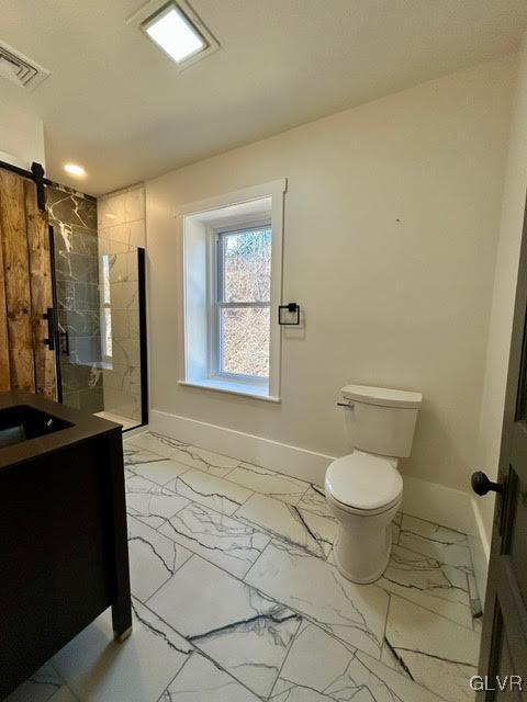 bathroom with marble finish floor, baseboards, a walk in shower, and vanity