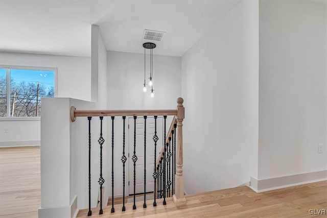 stairway featuring a notable chandelier and hardwood / wood-style floors