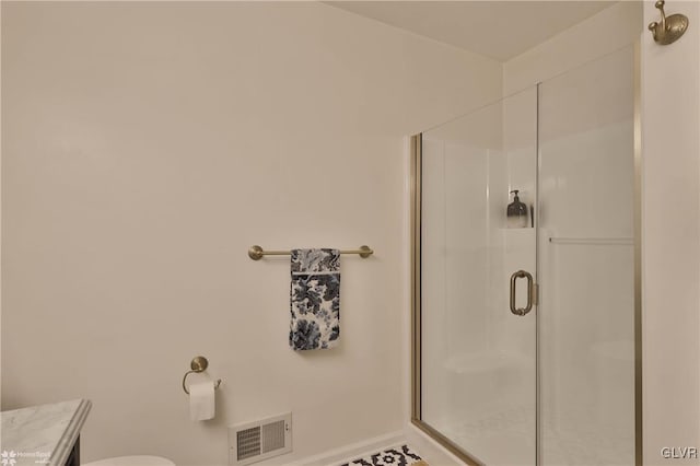 bathroom with an enclosed shower, vanity, and toilet