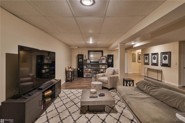 living room with a paneled ceiling and hardwood / wood-style flooring