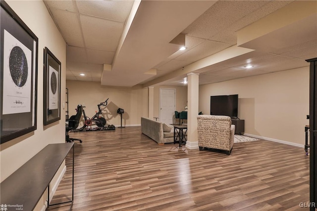 exercise room featuring a paneled ceiling and hardwood / wood-style flooring