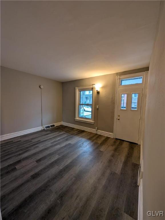 entrance foyer featuring dark wood-type flooring and a wealth of natural light