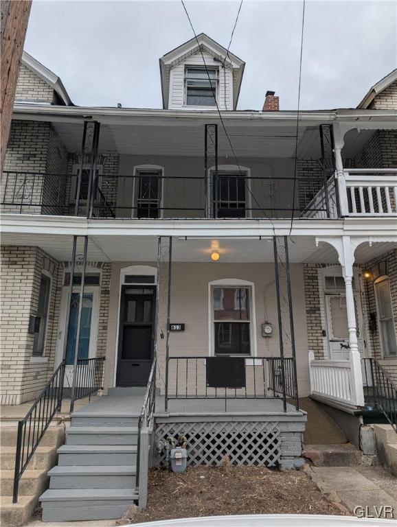 view of front of property featuring a balcony and covered porch