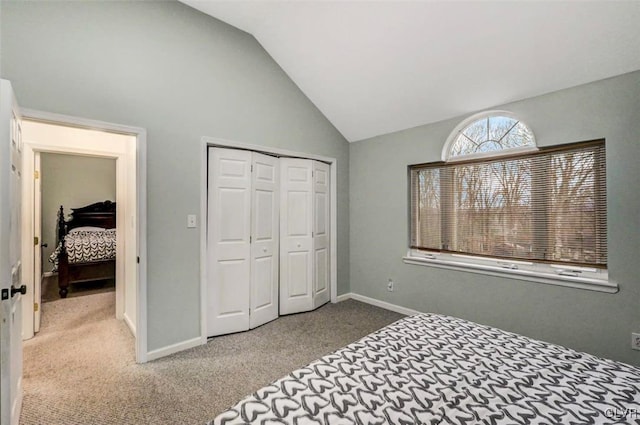 bedroom featuring a closet, vaulted ceiling, and light colored carpet