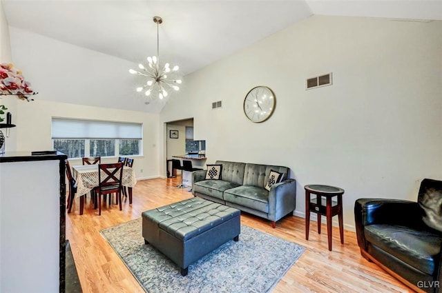 living room with light hardwood / wood-style floors, lofted ceiling, and a chandelier