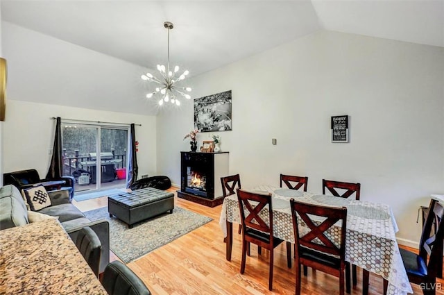 living room with lofted ceiling, a chandelier, and wood-type flooring