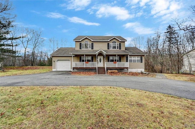 view of front of property with a porch, a front lawn, and a garage