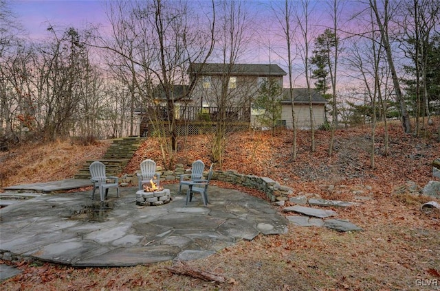 yard at dusk with an outdoor fire pit and a patio