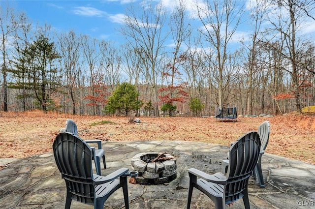 view of patio with a fire pit and a trampoline