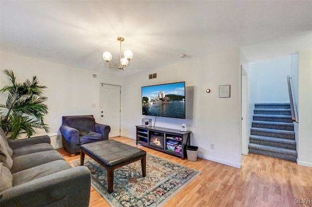 living room featuring light wood-type flooring and an inviting chandelier