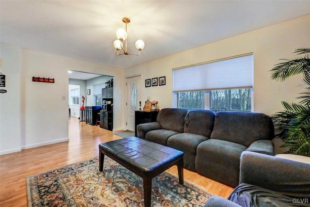 living room with light hardwood / wood-style floors and an inviting chandelier