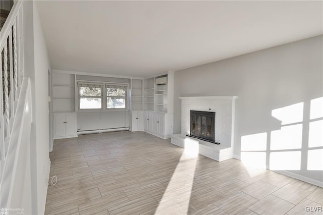 unfurnished living room featuring built in features, a brick fireplace, and a baseboard heating unit