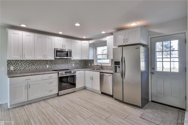 kitchen with sink, stainless steel appliances, a wealth of natural light, and white cabinetry