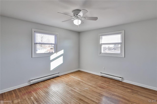 unfurnished room with a baseboard heating unit, light hardwood / wood-style flooring, and a wealth of natural light