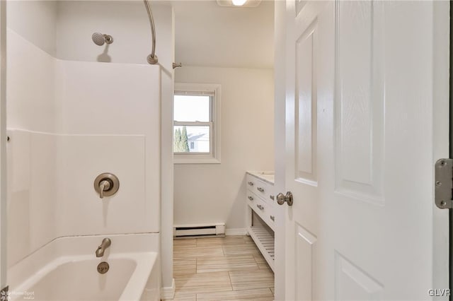 bathroom with baseboard heating, shower / bathing tub combination, and vanity