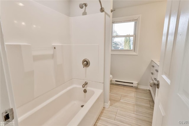 full bathroom featuring toilet, vanity, a baseboard heating unit, and tub / shower combination