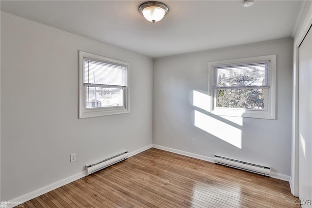 spare room with light wood-type flooring and a baseboard heating unit