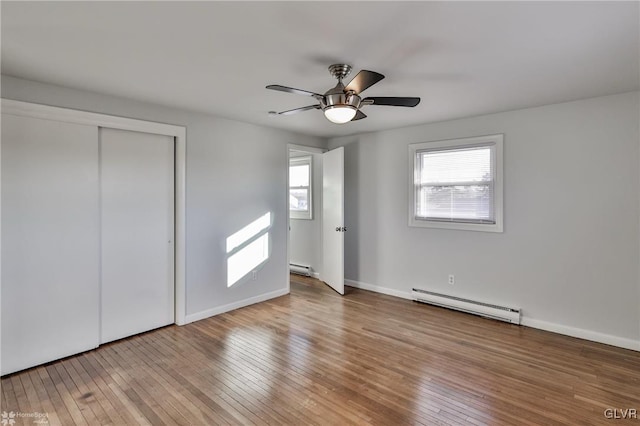 unfurnished bedroom featuring light wood-type flooring, ceiling fan, a baseboard radiator, and a closet