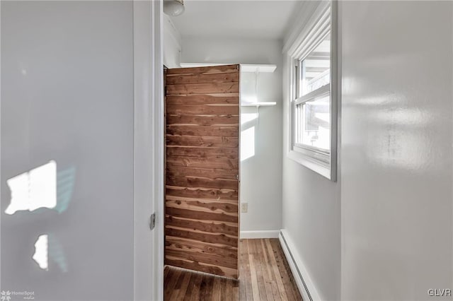 walk in closet with baseboard heating and wood-type flooring