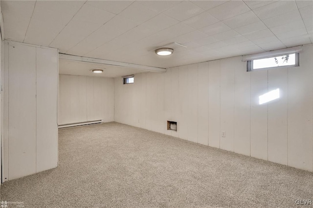 basement with wooden walls, a baseboard radiator, and carpet floors