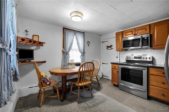 kitchen featuring light colored carpet, appliances with stainless steel finishes, and decorative backsplash