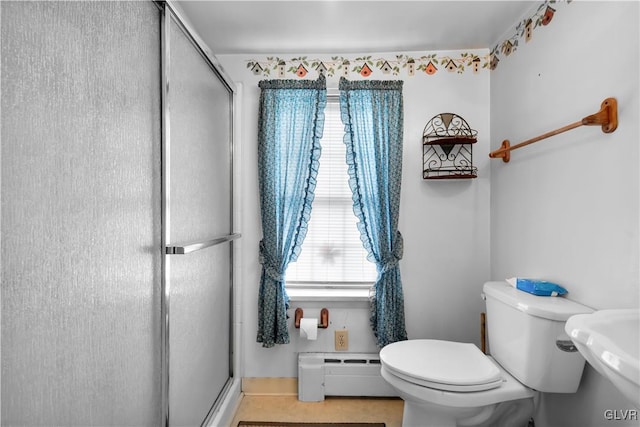 bathroom featuring toilet, a baseboard heating unit, tile patterned floors, a shower with shower door, and sink