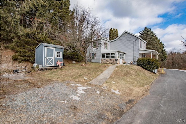 view of front of property featuring a shed