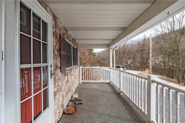 snow covered patio featuring a porch