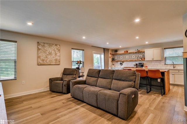 living room featuring sink and light hardwood / wood-style flooring