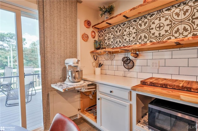 kitchen featuring white cabinets, wood counters, decorative backsplash, and hardwood / wood-style flooring