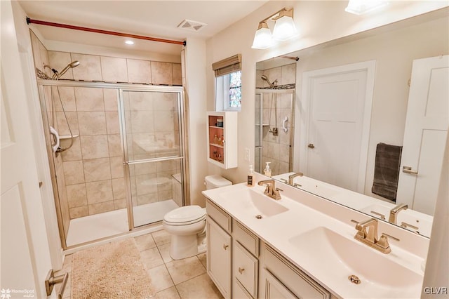 bathroom featuring toilet, a shower with door, tile patterned floors, and vanity