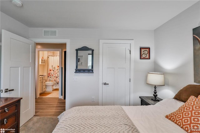 carpeted bedroom featuring ensuite bathroom