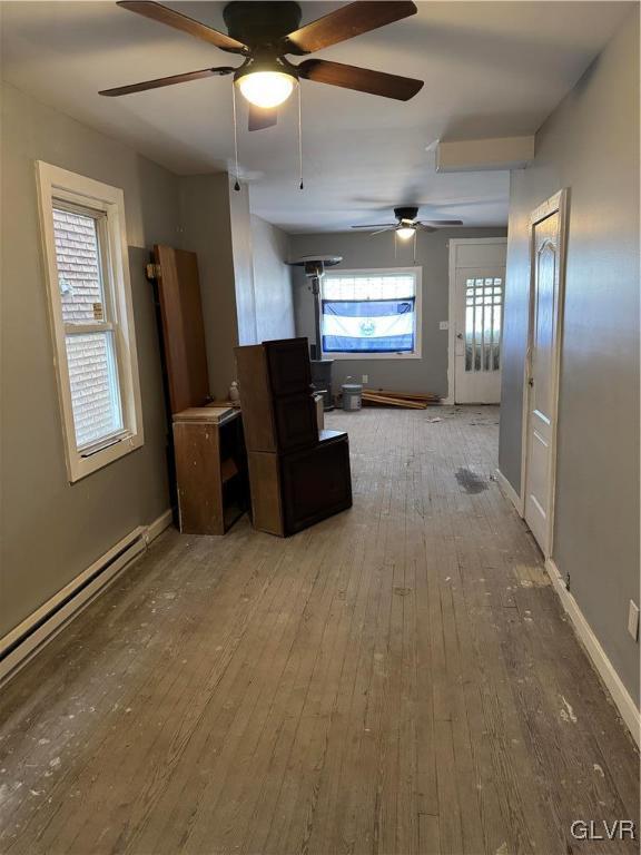 kitchen featuring ceiling fan, baseboard heating, and wood-type flooring