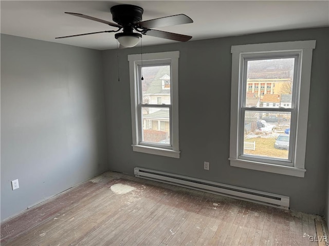 unfurnished room with a baseboard radiator, ceiling fan, plenty of natural light, and light hardwood / wood-style flooring