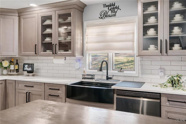 kitchen with sink, stainless steel dishwasher, and backsplash