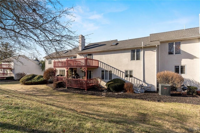 rear view of house featuring cooling unit, a deck, and a yard