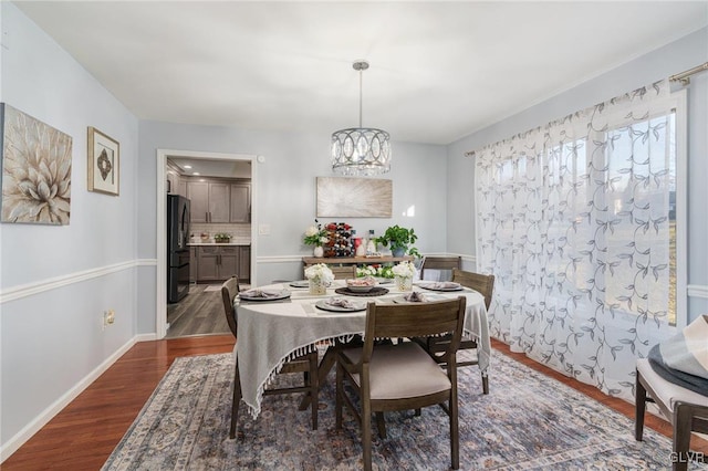 dining area with an inviting chandelier and dark wood-type flooring