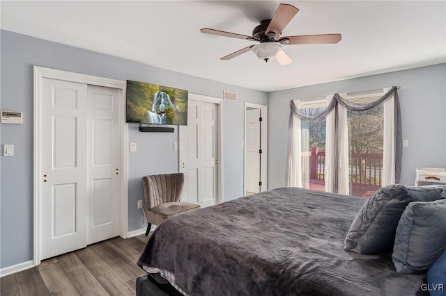 bedroom with hardwood / wood-style floors, ceiling fan, access to exterior, and multiple closets