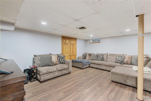 living room with a paneled ceiling and hardwood / wood-style floors