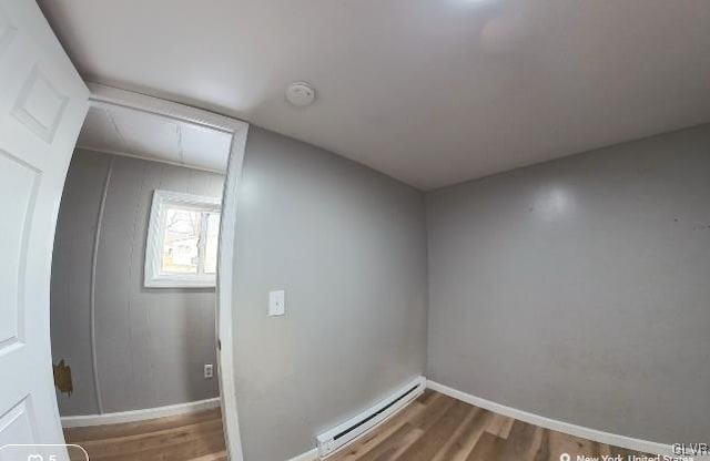 interior space with hardwood / wood-style floors and a baseboard radiator