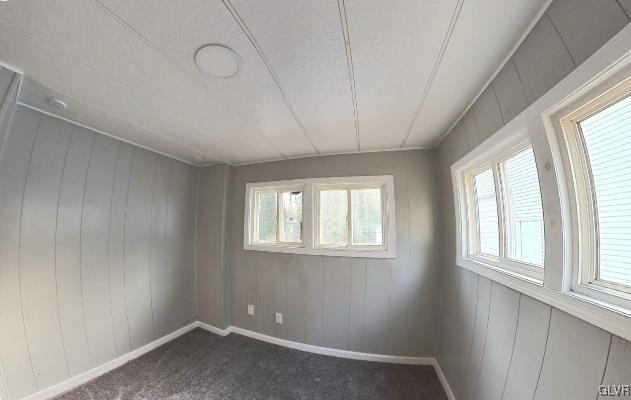 empty room featuring dark colored carpet