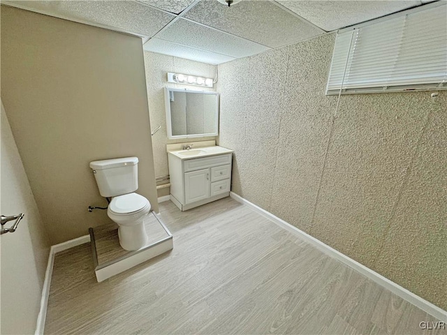 bathroom featuring hardwood / wood-style floors, toilet, a paneled ceiling, and vanity